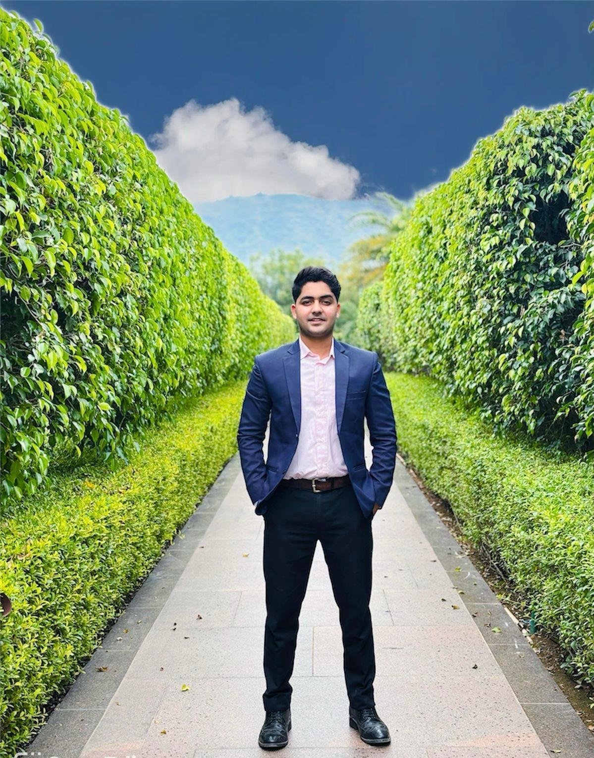 Monochrome studio portrait of Sidhant Awasthi, CEO of Bliss Knot Events. Dressed in a sharply tailored charcoal bespoke blazer with an open collar white shirt. Studio lighting highlights quiet confidence, piercing gaze, dignified composure, and refined executive leadership against an understated dark gray background.